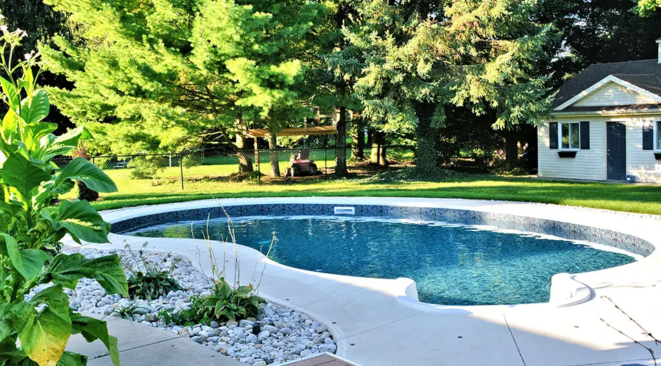 Finished backyard pool among mature trees
